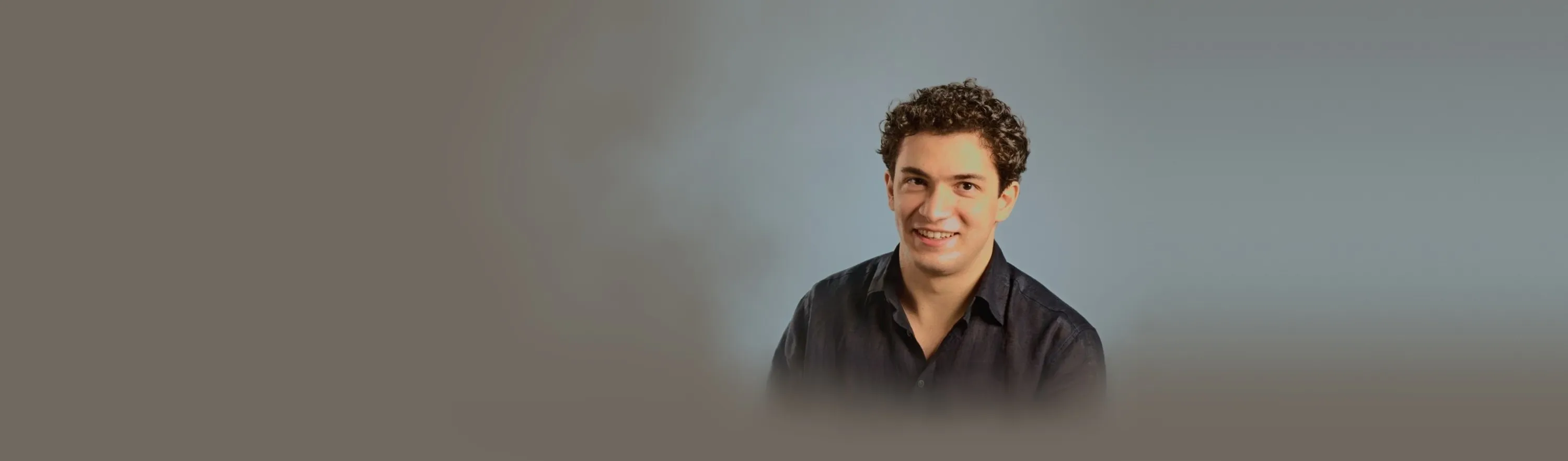 Baritone Biran Özgür Sariyer, studio portrait, smiling, navy shirt