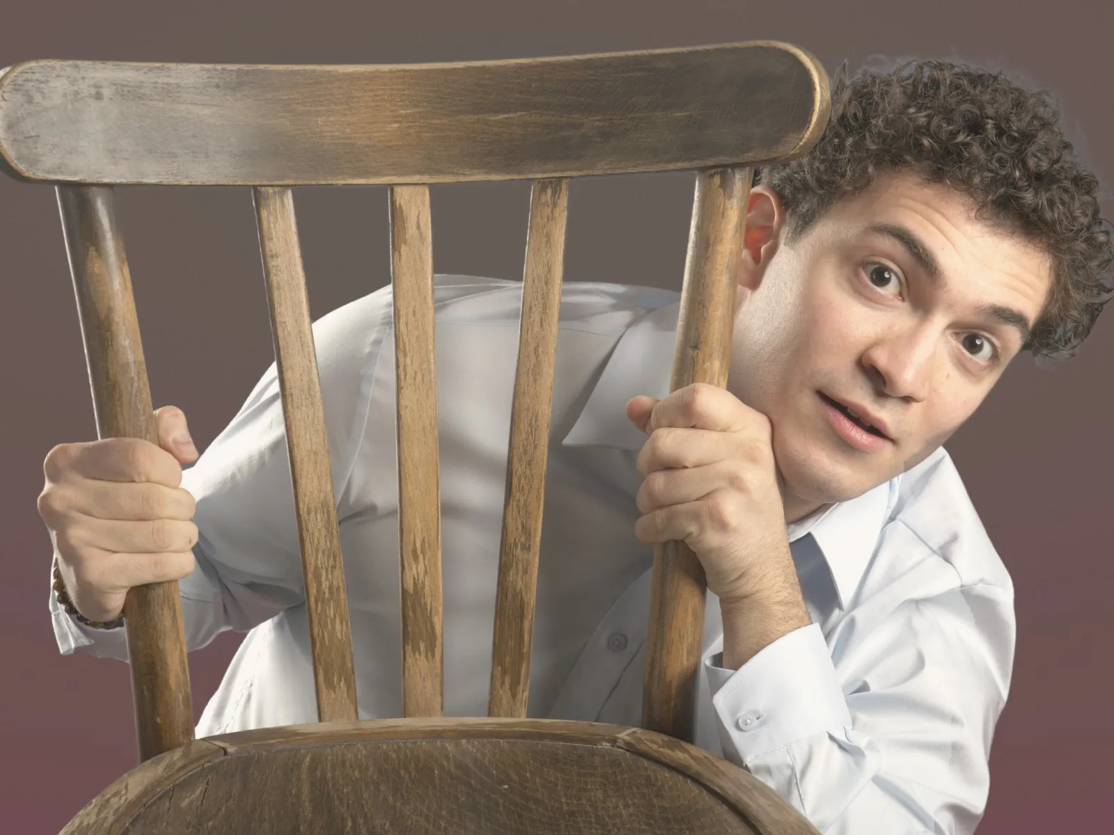 Baritone Biran Özgür Sariyer, studio portrait, peeking past a chair