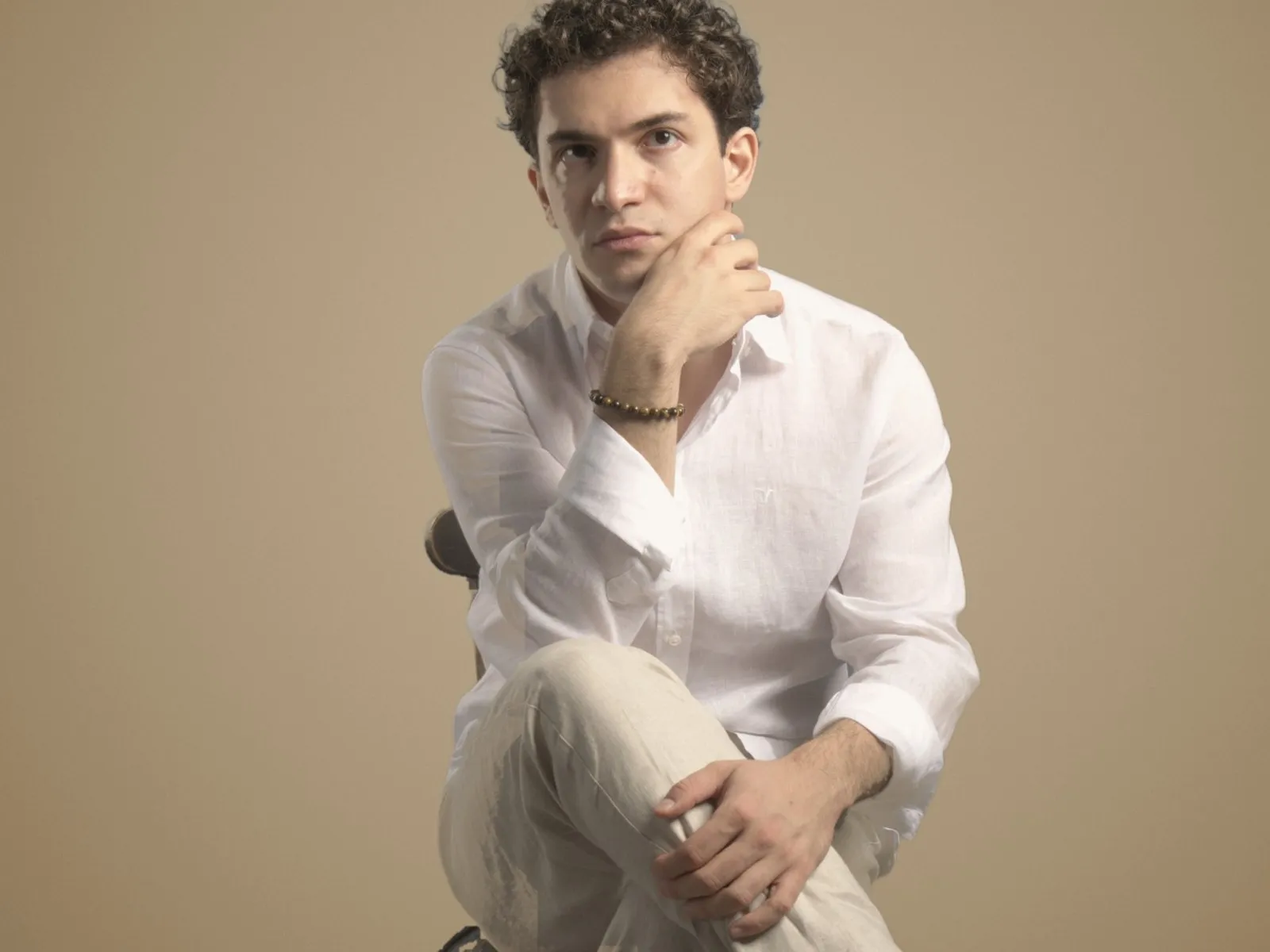 Baritone Biran Özgür Sariyer, studio portrait, thoughtful, white linen shirt