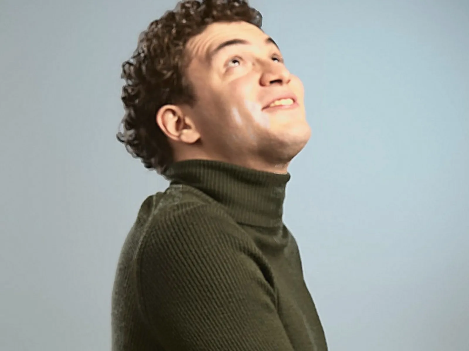 Baritone Biran Özgür Sariyer, studio portrait, looking up, listening