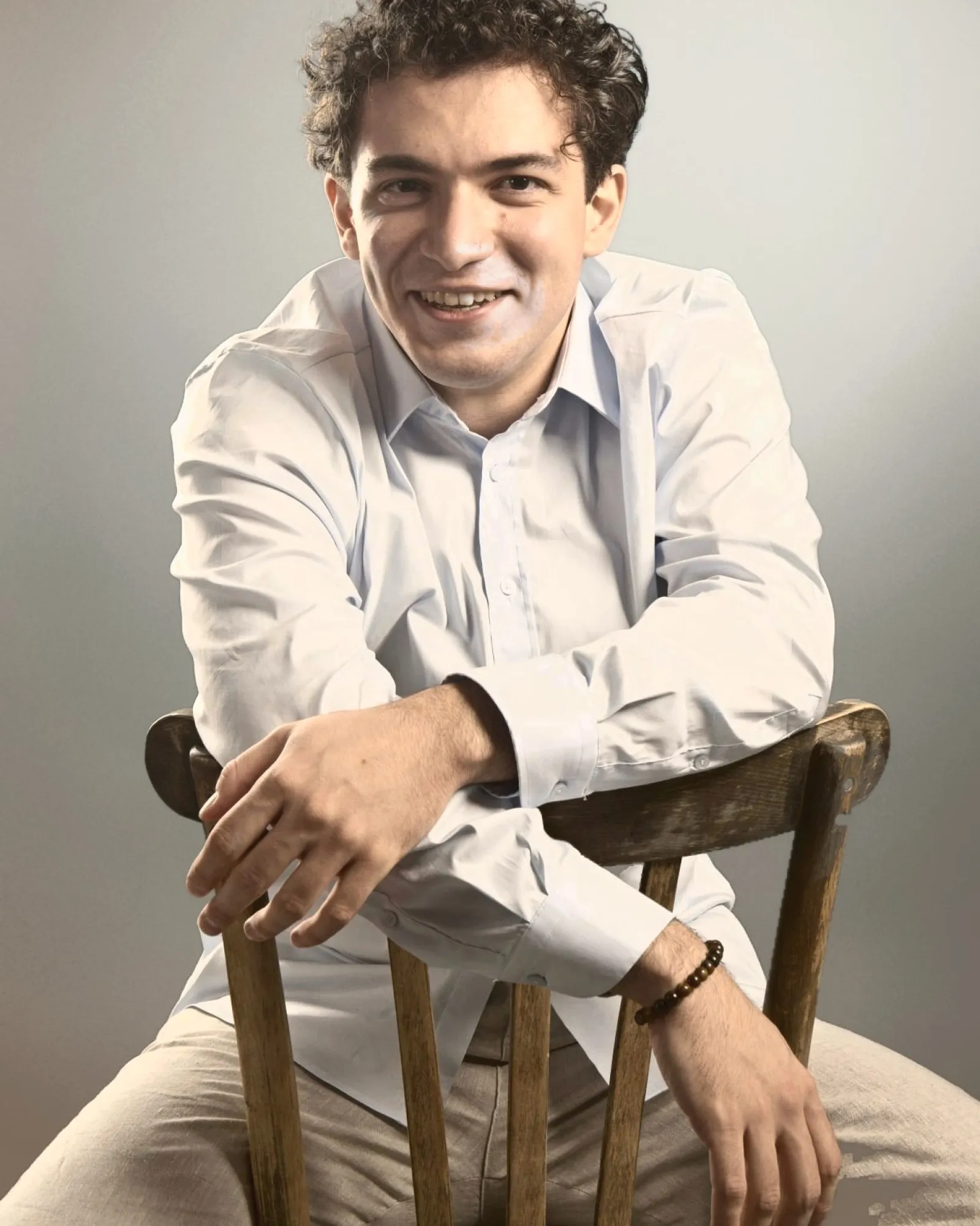 Baritone Biran Özgür Sariyer, studio portrait, smiling, light blue shirt