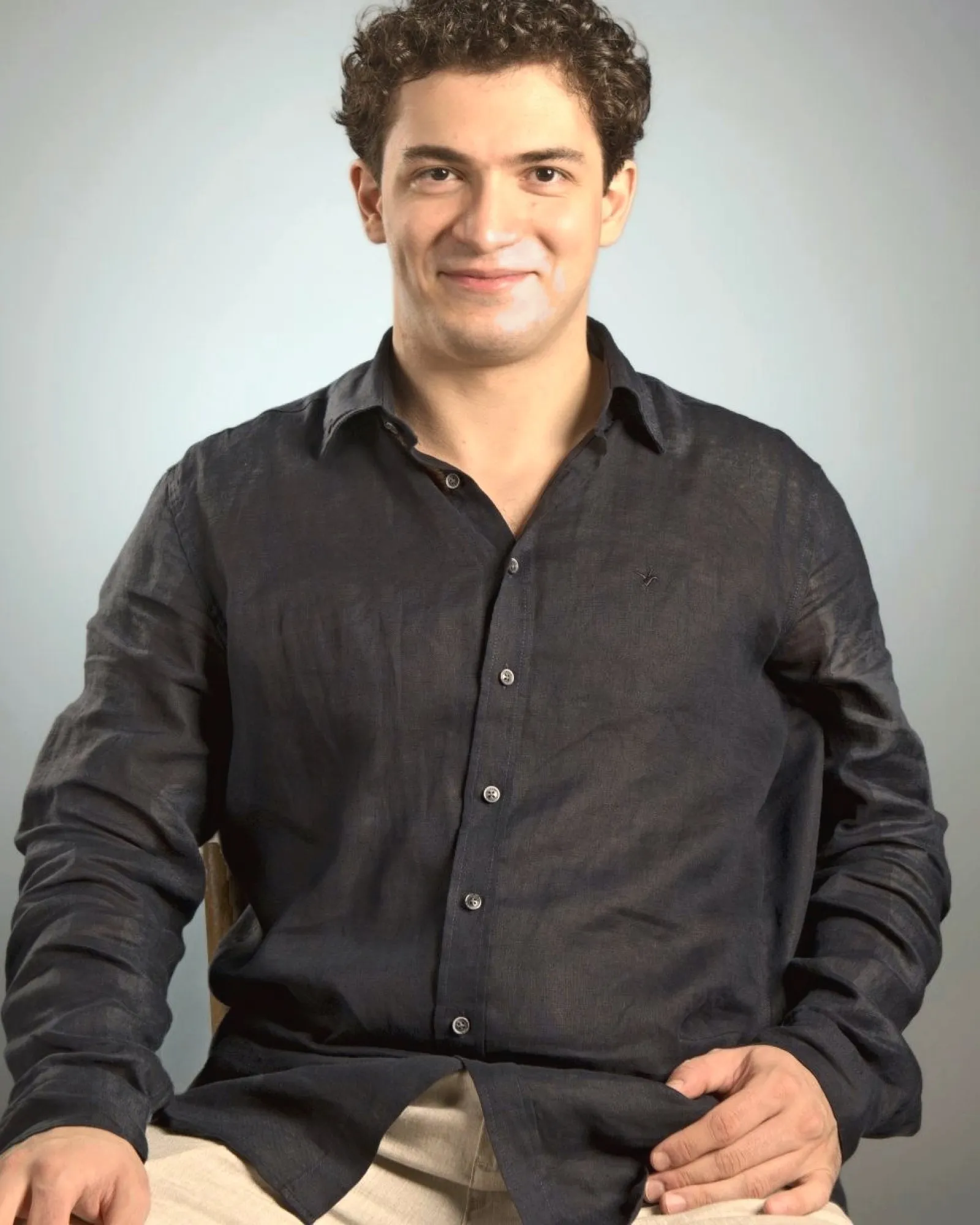 Baritone Biran Özgür Sariyer, studio portrait, smiling, navy shirt